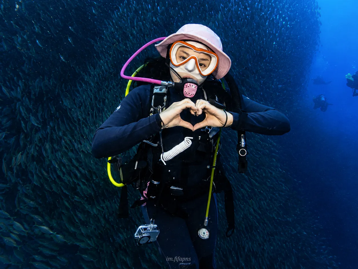 Diver underwater making a heart hand gesture