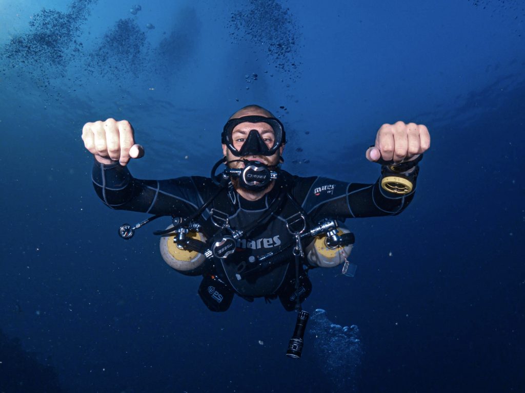 Sidemount diver exploring vibrant coral reefs in Koh Tao, Thailand, showcasing the flexibility and comfort of sidemount diving, ideal for SSI Advanced Course students at Koh Tao Scuba Club.